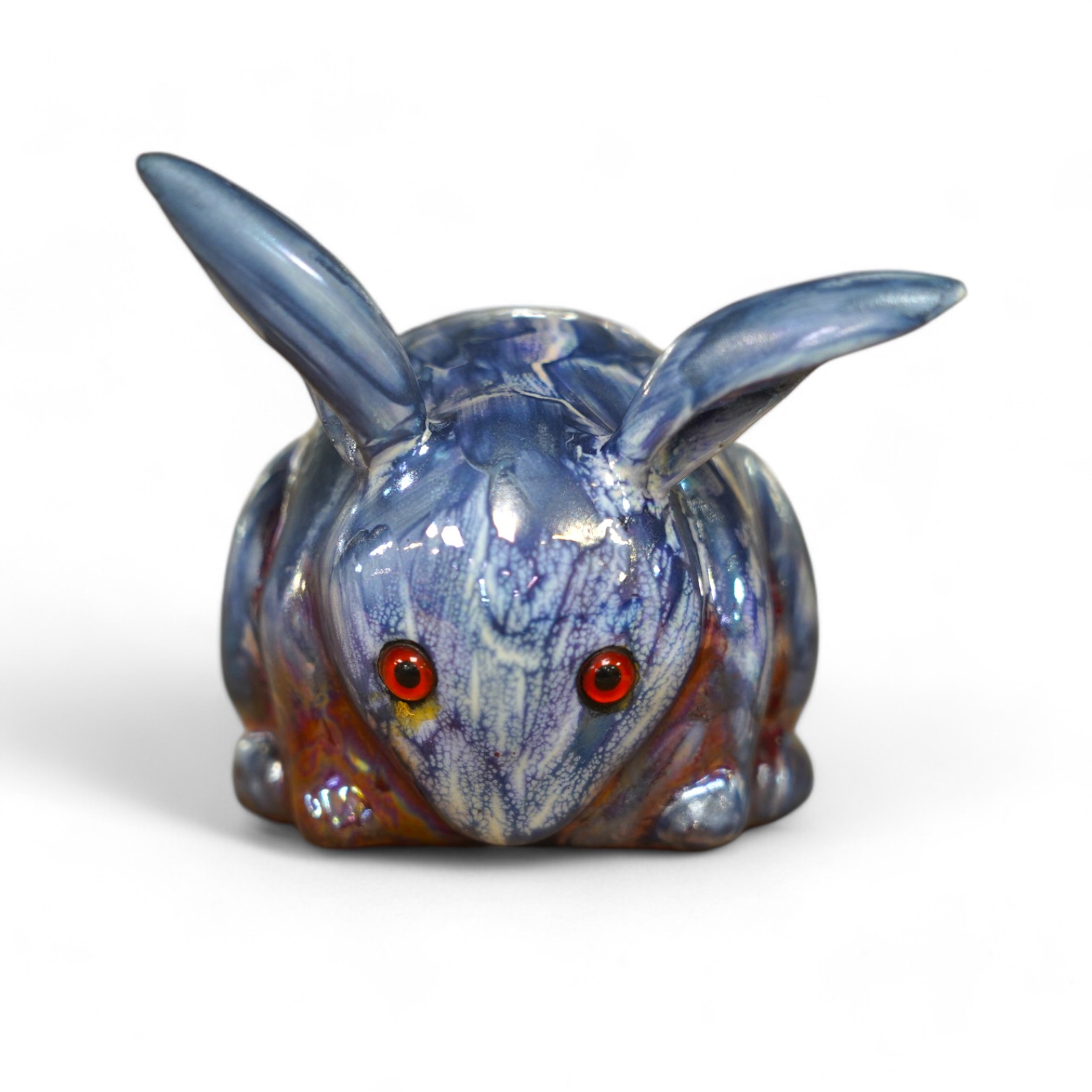 A Bernard Moore blue lustre rabbit with red glass eyes, c.1910, signed, 6cm high. Condition - good